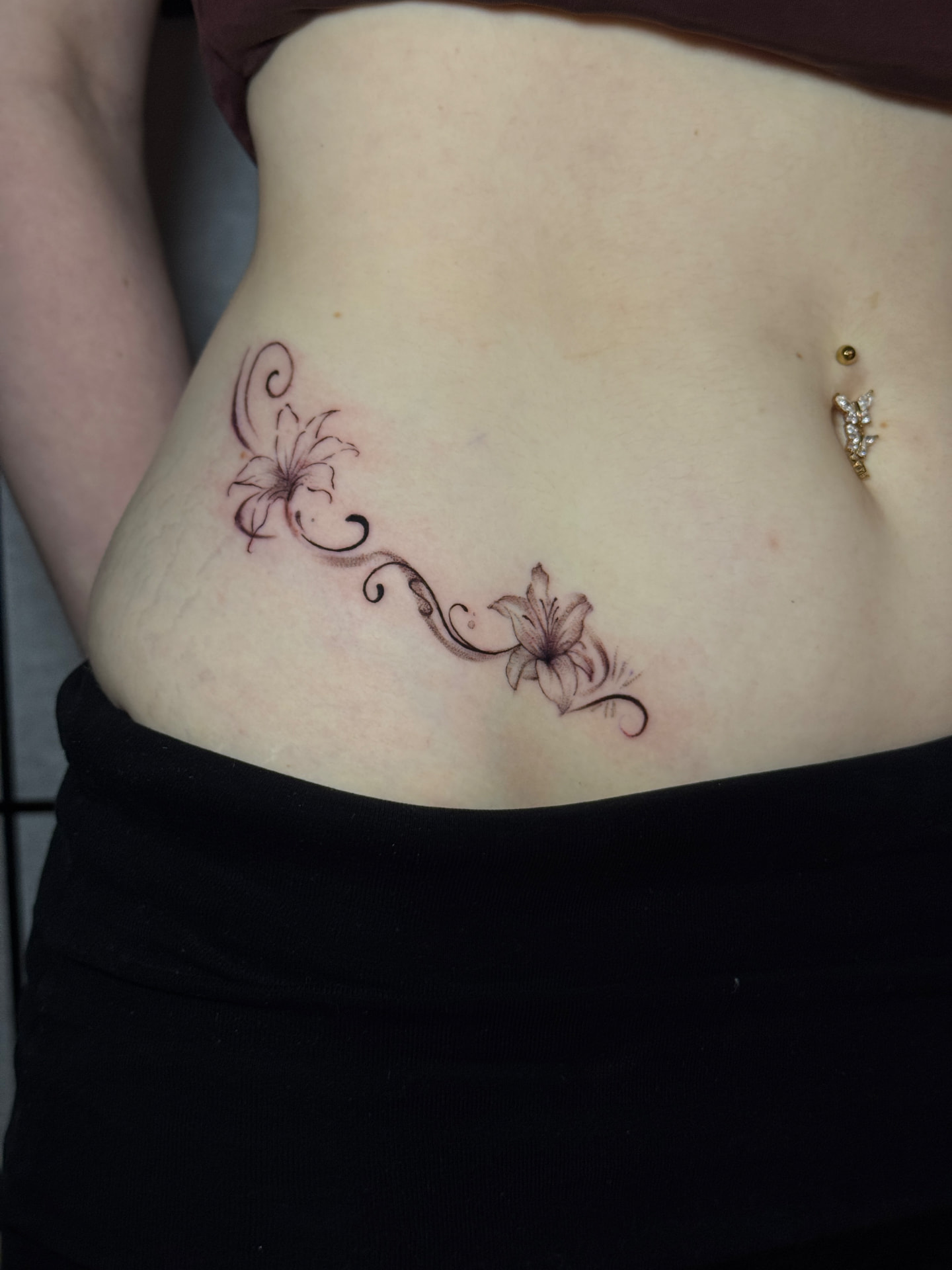 Filigranes Fine-Line-Tattoo mit Lilien von Omilian Tattoo in Laboe bei Kiel